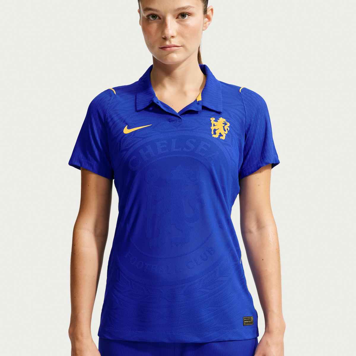 Person wearing a blue sports jersey with a logo on a white background