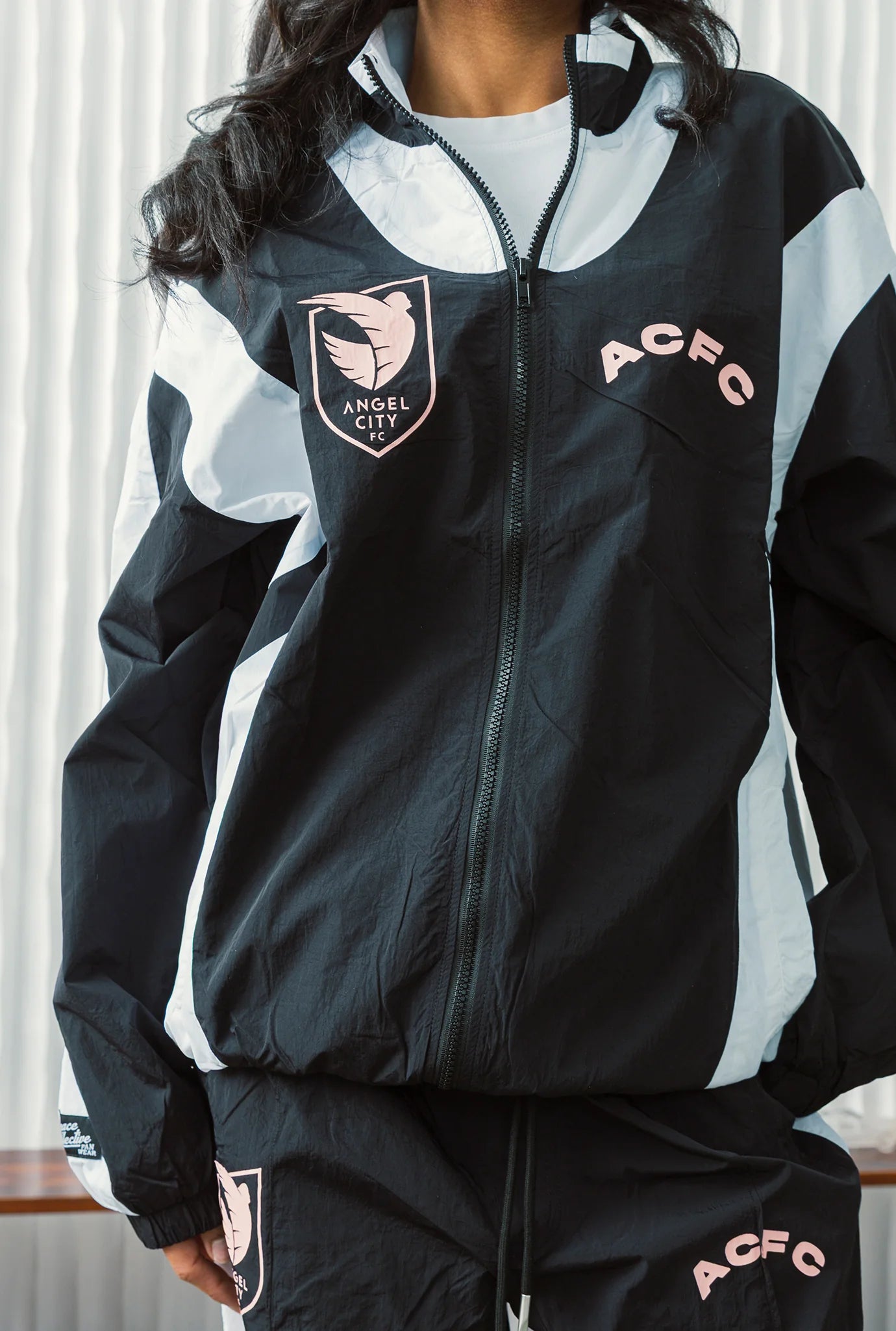 Person wearing a black and gray tracksuit with 'ACFC' branding