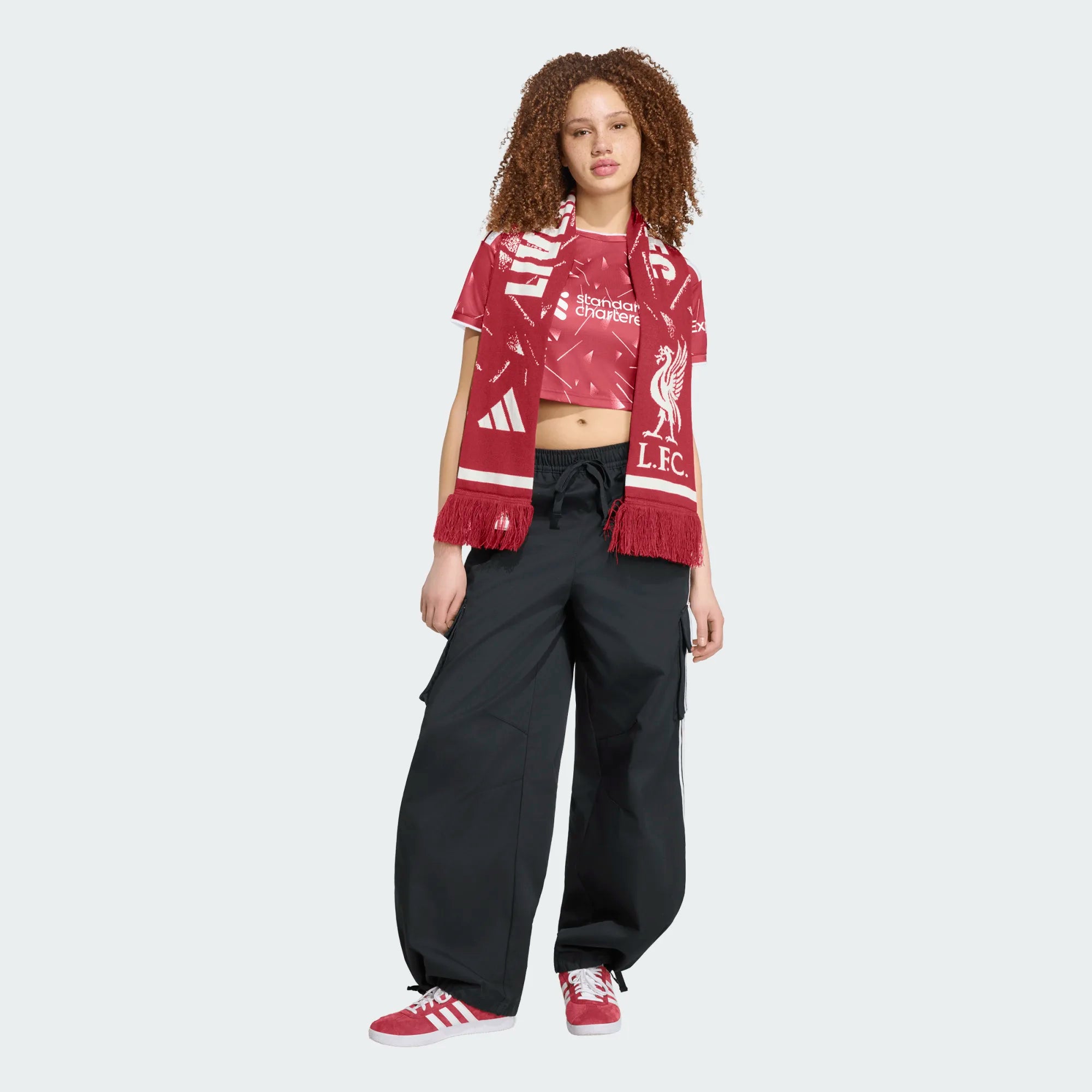 Person wearing a Liverpool FC scarf and black pants on a white background