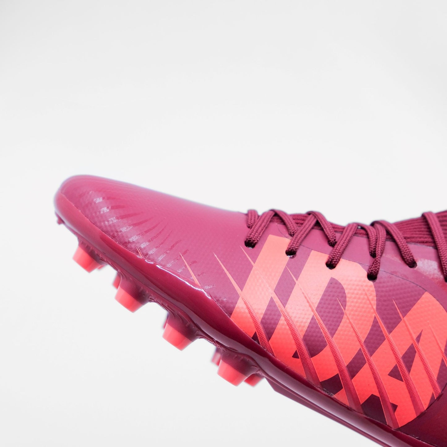 IDA Rise Women's Soccer Cleat, Burgundy, FG/AG, Firm Ground, Artificial Ground, Ankle sock, zoom in on the toe box and I-D-A spelled out in big light coral letters